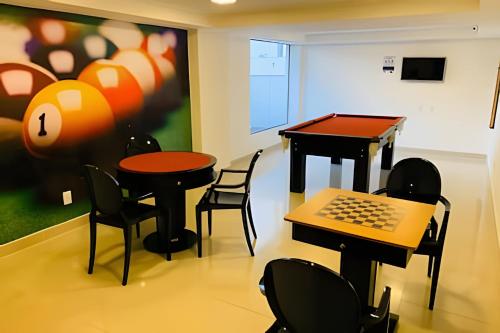 a room with two tables and chairs and a laptop at Gold Flat com Café by Apartamentos Jampa in João Pessoa