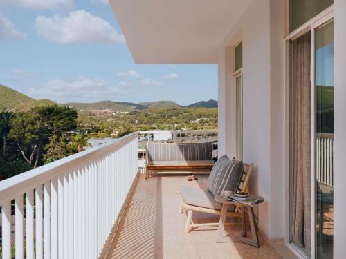 a balcony with chairs and a view of the mountains at Hyde Ibiza in Cala Llonga