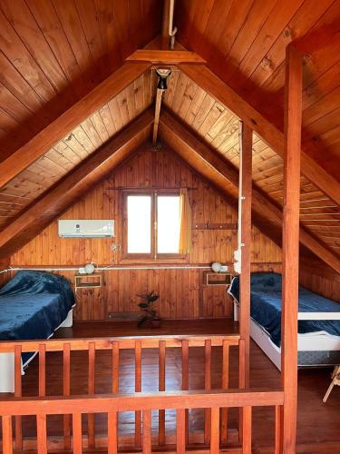 a bedroom with two beds in a wooden cabin at Olivillos frente al mar in Balneario Pehuén-Có