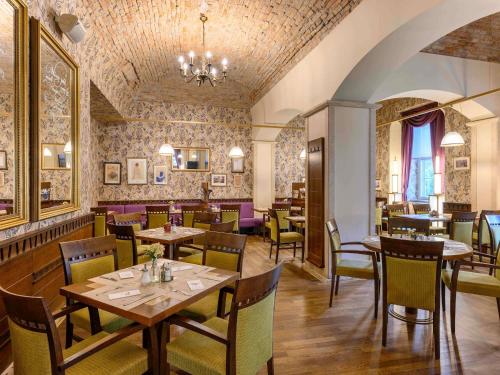 a restaurant with tables and chairs in a room at Mercure Szekesfehervar Magyar Kiraly in Székesfehérvár