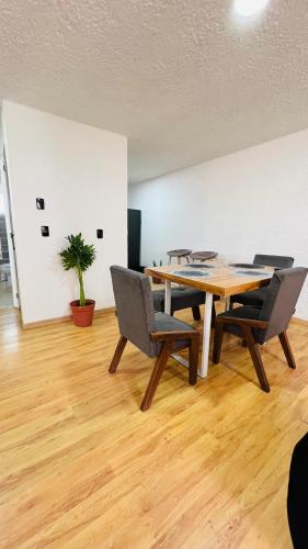 a dining room with a wooden table and chairs at Departamento Guadalajara Expo Downtown Chapultepec in Guadalajara