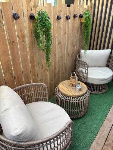 two wicker chairs and a table on a fence at Opalys spa 