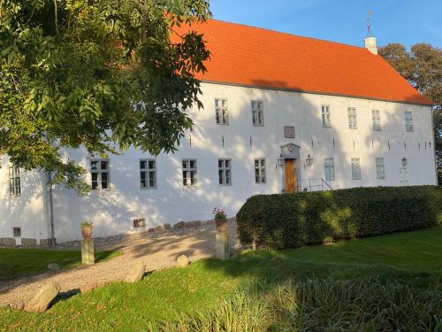 a large white building with an orange roof at Staarup Hovedgaard in Højslev
