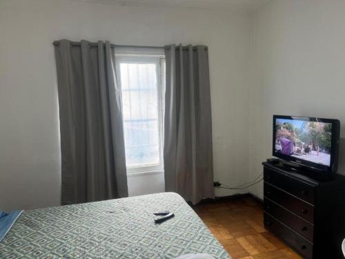a bedroom with a television on a dresser and a window at Hostal Casa Gloria Home in Viña del Mar