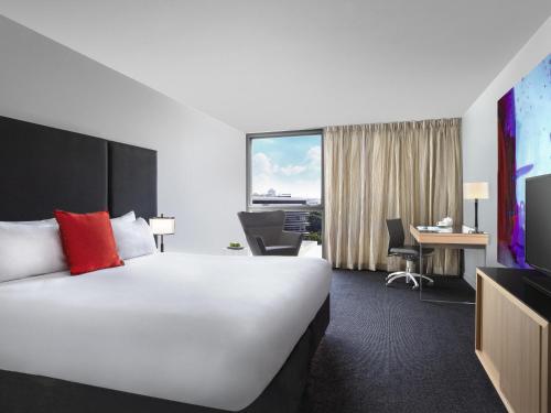 a hotel room with a large bed and a desk at Mantra South Bank Brisbane in Brisbane