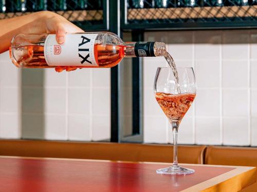 a person pouring wine into a wine glass at Mantra South Bank Brisbane in Brisbane