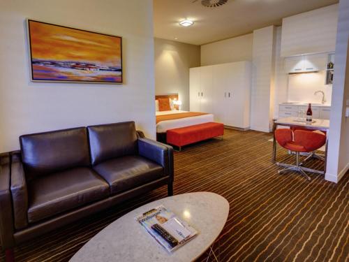 a hotel room with a couch and a bed at Mantra Charles Hotel in Launceston