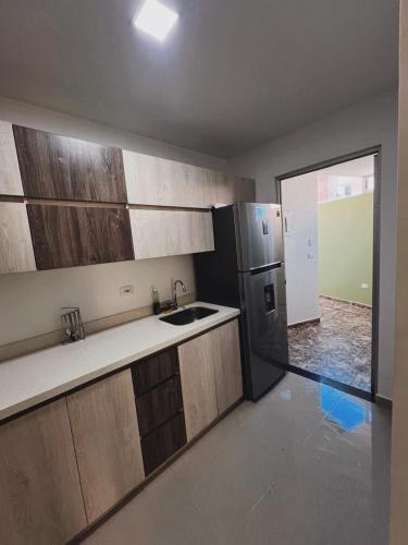 a kitchen with wooden cabinets and a stainless steel refrigerator at Apartamento en Rionegro in Rionegro