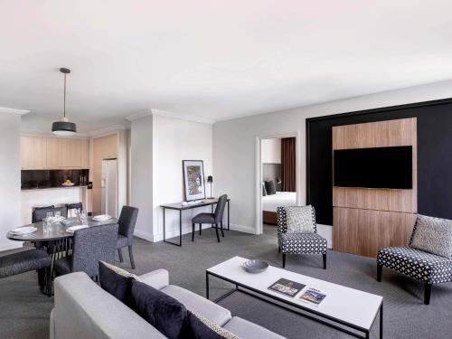 a living room with a couch and a table at Mantra on Little Bourke Melbourne in Melbourne