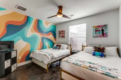 two beds in a room with a colorful wall at The Q - Austin Family Home - Hot Tub & Golf Sim in Austin