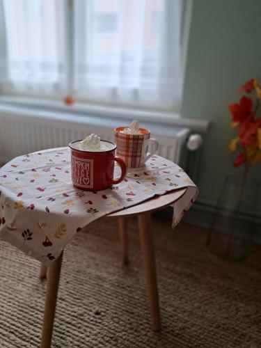 a table with a table cloth with a cup on it at Igali Varázs Apartman 150 méter a fürdőtől in Igal
