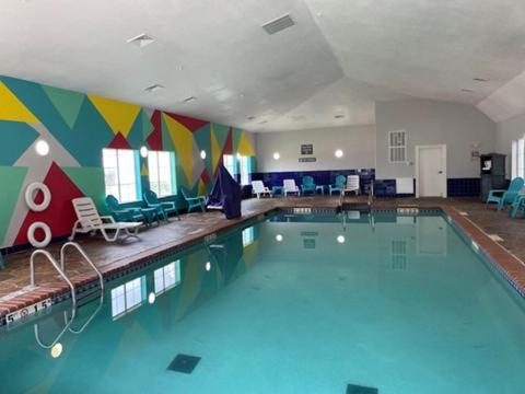 a swimming pool in a room with a mural at La Quinta by Wyndham Oklahoma City - Moore in Moore