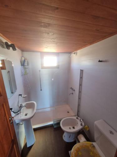 a bathroom with two sinks and a shower and a toilet at Olivillos frente al mar in Balneario Pehuén-Có
