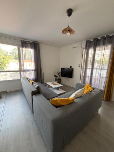a living room with a couch and a tv at Villejuif - Métro Léo Lagrange - 2 pièces avec balcon in Villejuif