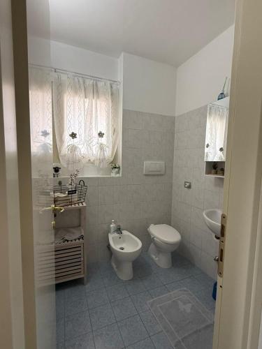 a white bathroom with a toilet and a sink at The Happy Place Montecatini in Montecatini Terme