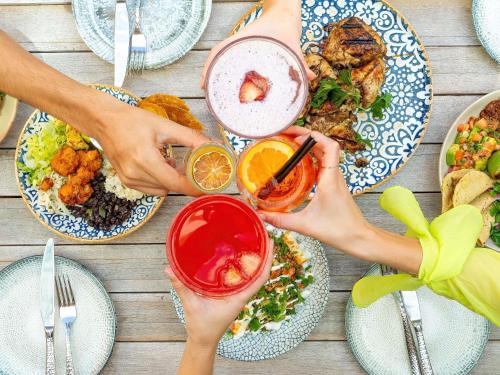a group of people sitting at a table with plates of food at The Adnate Perth - Art Series in Perth