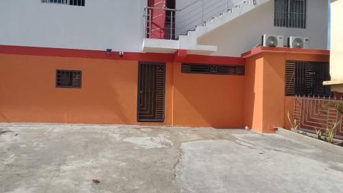 an orange and white building with black windows at The perfect place in Samana in Santa Bárbara de Samaná