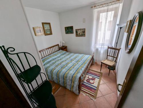 una camera da letto con un letto, due sedie e una finestra di Piacevole alloggio di montagna per 4 persone a Limone Piemonte