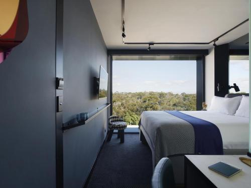 a hotel room with a bed and a large window at Tribe Perth Kings Park in Perth