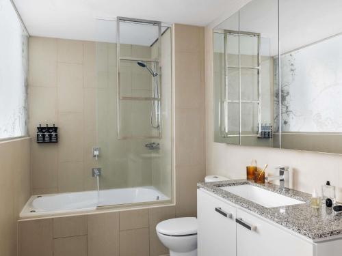 Un baño con bañera, inodoro y lavabo. en The Olsen Melbourne Art Series, en Melbourne