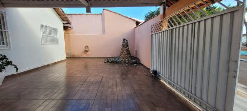 an empty courtyard with a fence and a christmas tree at Casa privativa e aconchegante com área de lazer in São Sebastião do Paraíso