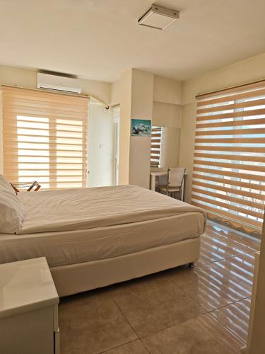 a bedroom with a bed and a table and windows at HD Miray Otel in Tosya