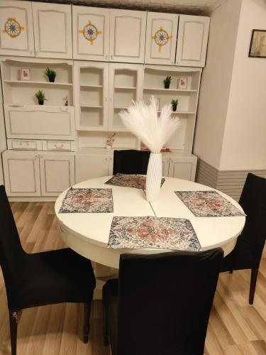 a dining room with a white table and black chairs at Friendly apartment in Sigulda