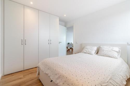 Un dormitorio blanco con una cama y armarios blancos. en Skyview Las Palmas, en Las Palmas de Gran Canaria