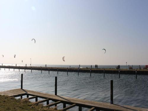 a group of kites flying over the water near a pier at Ferienwohnung direkt am Hafen in Fehmarn-Orth in Orth