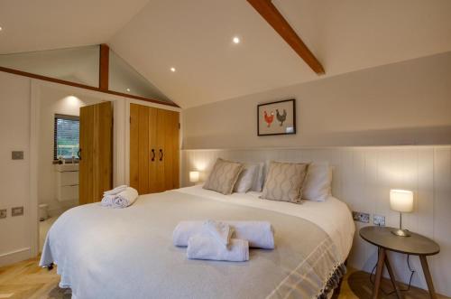 a bedroom with a large white bed with towels on it at The Granary in Banningham