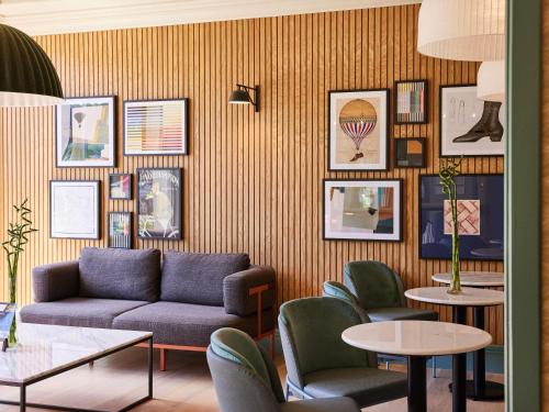 a living room with a couch and chairs and tables at Mercure Northampton in Northampton