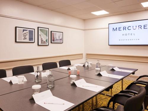 a conference room with a long table and chairs at Mercure Northampton in Northampton