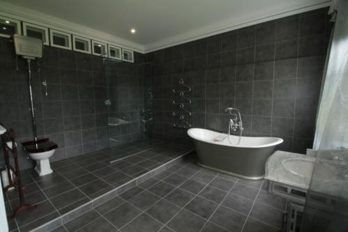 a bathroom with a tub and a toilet and a sink at Prince Hill House in Devizes