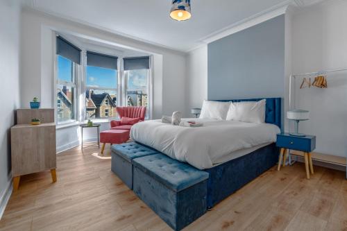 a bedroom with a king sized bed and a red chair at Spacious 3BR unit w/ free parking in Bristol