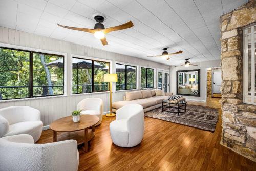 een woonkamer met een bank en een plafondventilator bij Lake Access Pool Loungers Fire Pit Grill in McQueeney