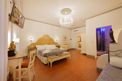 um quarto com uma cama e uma mesa num quarto em Palazzo Mari suite & rooms b&b em Montevarchi