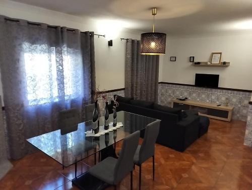 a living room with a glass table and a couch at Casa Manos Névoa in Geres