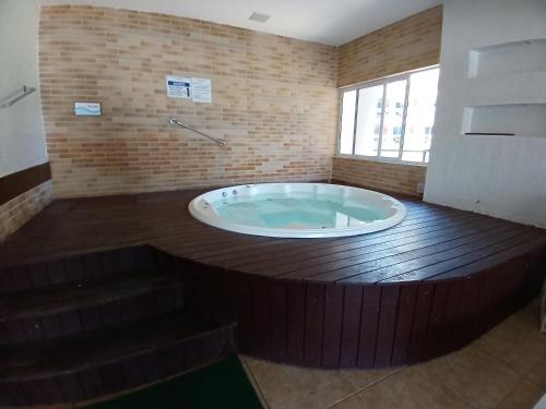 a jacuzzi tub in a room with a wooden floor at Apto 3 quartos Portamaris Pé na Areia Porto das Dunas in Aquiraz