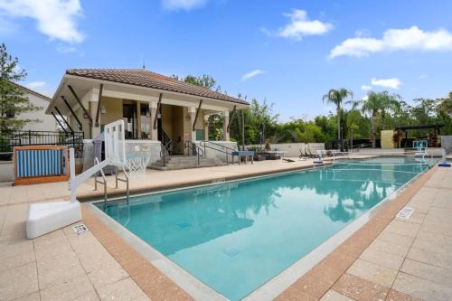 a swimming pool in front of a house at Cozy & Elegant 4BR Enchanted Townhouse - 1 Mile to Disney with Resort Pool, Gym, & Jacuzzi in Orlando