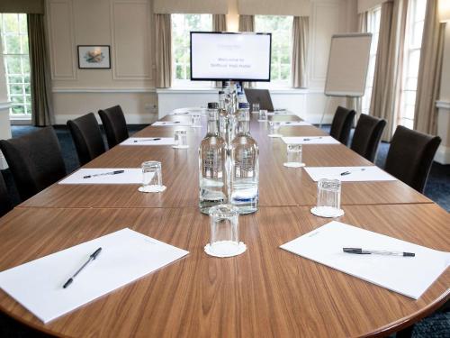 a conference room with a long table with wine bottles at Mercure Thurrock Stifford Hall in Grays Thurrock