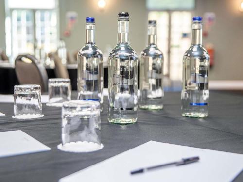 a table with wine bottles and glasses on it at Mercure Thurrock Stifford Hall in Grays Thurrock