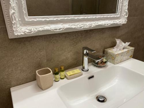 ヴォルテッラにあるVolterra View - in centro a piediの白いバスルームの洗面台(鏡付)