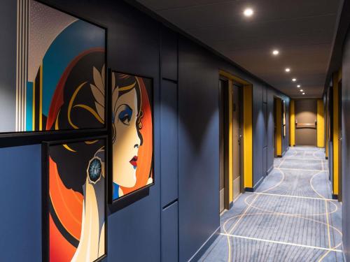a hallway with colorful paintings on the walls at ibis Styles Saint-Quentin in Saint-Quentin