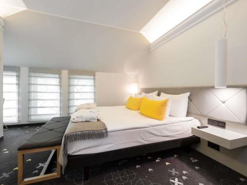 a bedroom with a large bed with yellow pillows at ibis Styles Tallinn in Tallinn