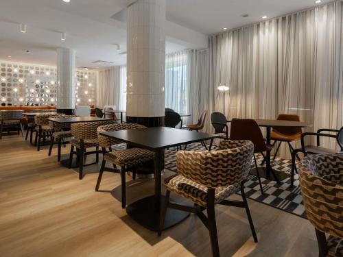 a restaurant with tables and chairs in a room at ibis Styles Tallinn in Tallinn