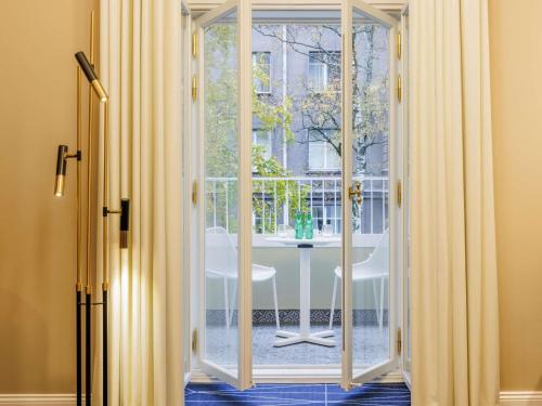 an open door to a balcony with a table outside at Movenpick Hotel Tallinn in Tallinn