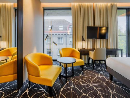 a hotel room with a bed and a table and chairs at Movenpick Hotel Tallinn in Tallinn