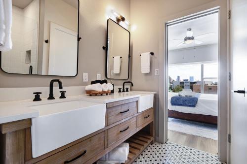 a bathroom with two sinks and a large mirror at Hanger - A Birdy Vacation Rental in San Antonio