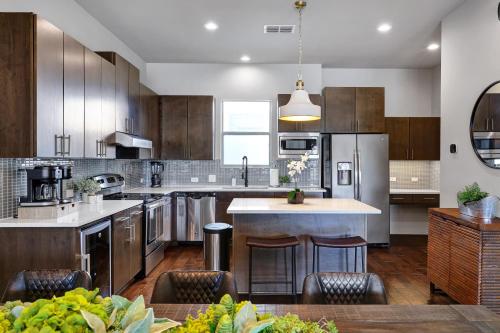 a kitchen with stainless steel appliances and wooden cabinets at Hanger - A Birdy Vacation Rental in San Antonio