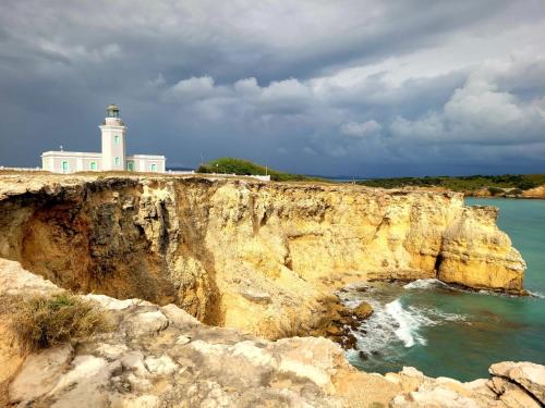 a lighthouse sitting on top of a cliff near the ocean at Ostiones Beach Property in Garita